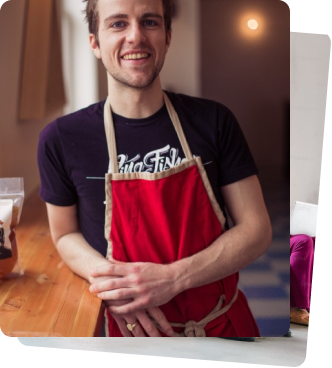 A male person on a red apron smiling